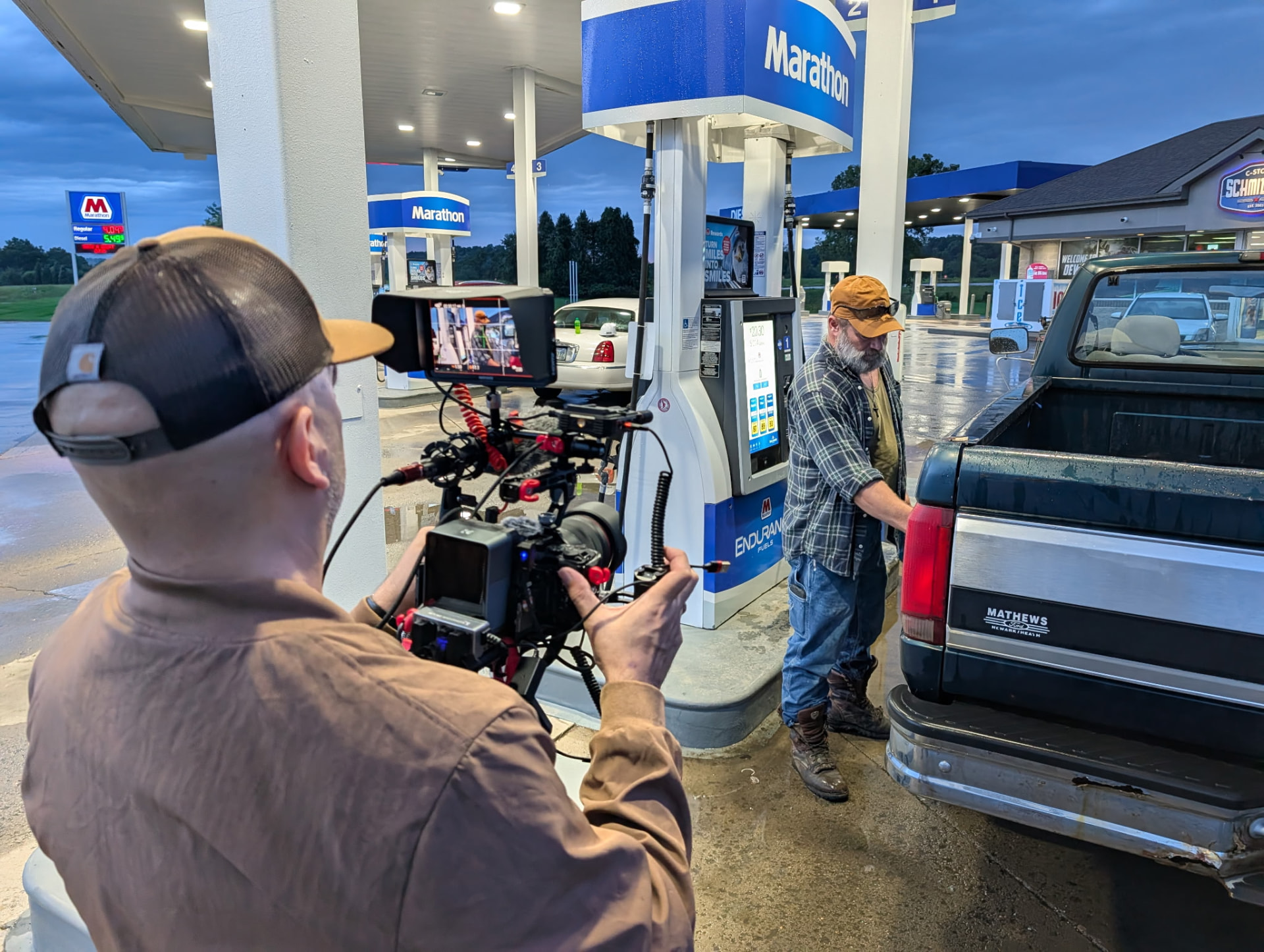 Director of photography filming a scene at a Marathon station at blue hour in Muskingum County, Ohio